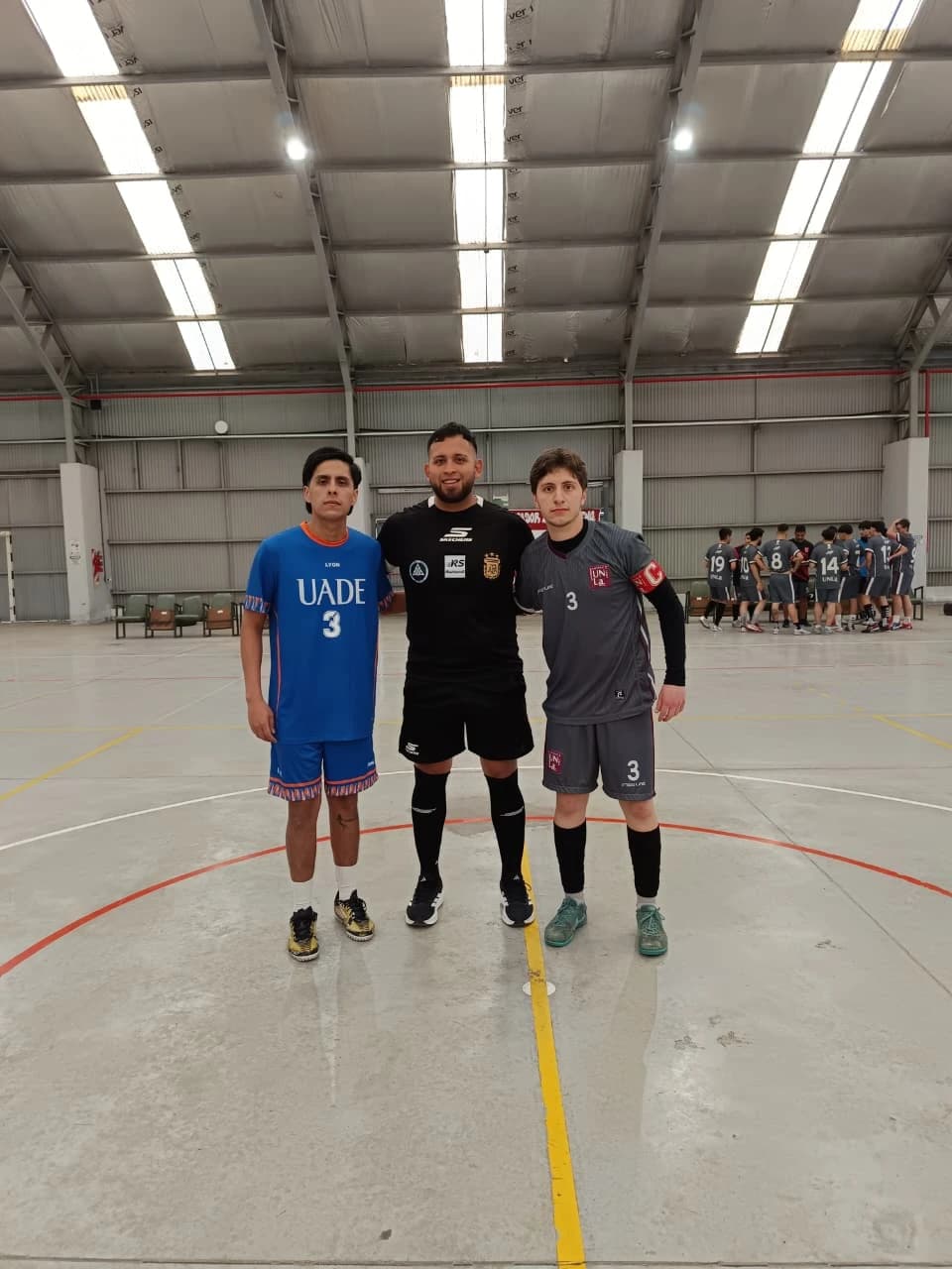Capitanes de UADE y UNLa Blanco junto al árbitro